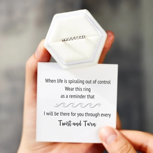 Close-up of a s925 silver twisted ring in a velvet box with an inspirational message card