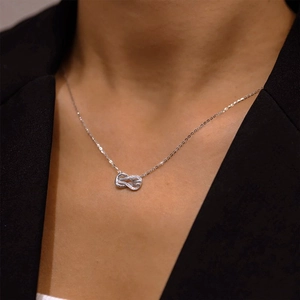 Collier nœud infini en argent sterling S925 avec zircons porté par un mannequin en blazer