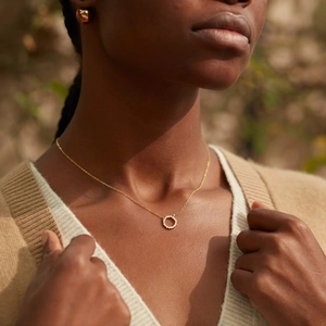 Collana a cerchio in argento s925 con zircone su modella sotto la luce naturale del sole