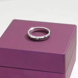 S925 sterling silver ring with I Am Enough engraving on a purple velvet jewelry box