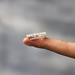 Macro shot of elegant S925 sterling silver ring with delicate white pearls and cubic zirconia