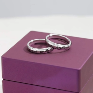 Macro detail of silver S925 rings with I Am Enough engraving on purple jewelry box