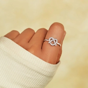 Elegant S925 sterling silver pretzel heart knot ring with cubic zirconia on model finger