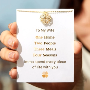 Detail of gold clover necklace with heart petals and diamonds on a romantic gift card