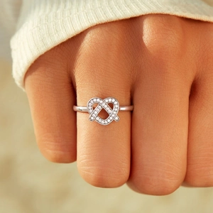 Elegant 925 sterling silver heart infinity ring with pave-set cubic zirconia on finger