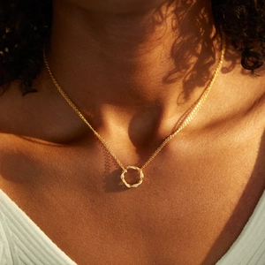Elegant s925 gold twisted pavé zircon ring necklace on model in warm sunlight