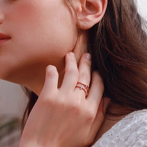 Close-up of double-layer rose gold cross ring with pavé cubic zirconia on model finger