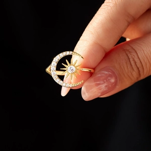 Detailed macro view of 18K gold star and moon ring with sparkling zircon stones