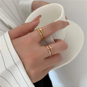 Detail shot of double-layer silver cross ring with sparkling zircon stones on finger