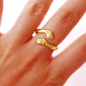 Anello in argento s925 dorato con mani che si abbracciano indossato da una modella