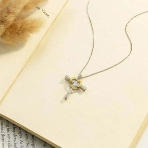Collier cœur croix en argent S925 avec pendentif zircon sur fond de livre ouvert