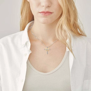 Élégant collier cœur et croix en argent s925 avec zircons bleus porté par un modèle