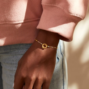 Detail of s925 silver bracelet with interlocking gold rings and colorful enamel beads