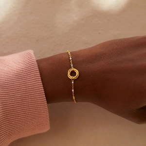 Detail of s925 silver gold bracelet with three interlocking rings and colorful enamel beads