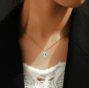 Close-up of S925 sterling silver star necklace with blue gemstone on model neck