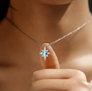 Detailed view of s925 silver star pendant with light blue gemstone and zircon accents