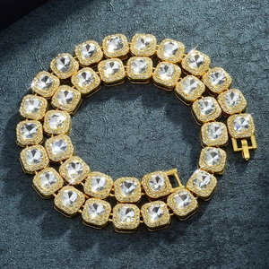 Goldene Hip-Hop-Kette mit 12mm quadratischen Strasssteinen auf grauem Steinhintergrund