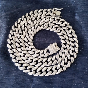 Dettaglio macro della catena cubana argento da 12 mm con strass brillanti e chiusura a cassetta