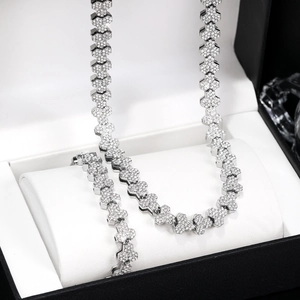 Detalle del conjunto de collar y pulsera plateados con pedrería en diseño de panal