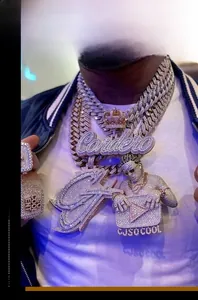Close-up of layered iced-out hip hop necklaces with crown and custom Cardero letter pendants