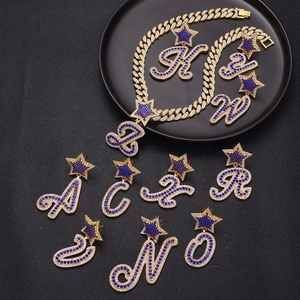 Iced out gold Cuban link chain with blue rhinestone alphabet pendants and star accents
