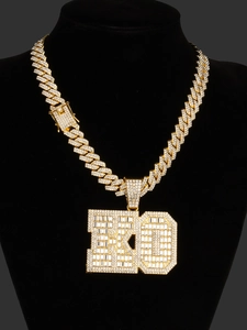 Macro detail of gold-plated iced out Cuban link chain with KD initial letter pendant