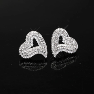 Macro view of silver heart earrings with micro-pave cubic zirconia on reflective surface