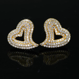 Elegant gold heart earrings with white cubic zirconia pavé on black reflective surface