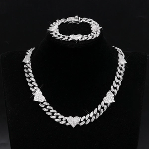 Iced out silver cuban chain jewelry set with sparkling heart charms on black display