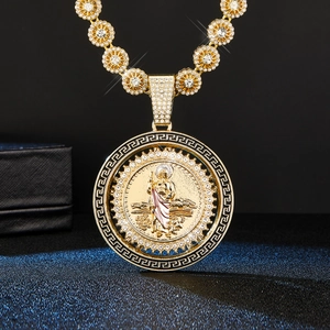 Détail macro du pendentif Saint Jude doré avec cristaux brillants et motif grec classique