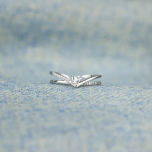 Macro shot of V-shaped S925 silver ring with pavé stones and heart-cut centerpiece