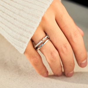 Dual-layer S925 silver infinity ring set with sparkling zircons on a warm fabric background