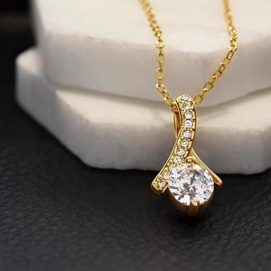 Dettaglio macro del ciondolo a nastro in argento S925 dorato con zirconi brillanti