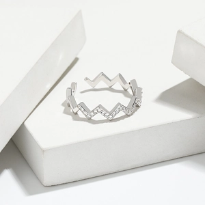 Close-up of S925 sterling silver wavy ring with pavé zircons on white stone base