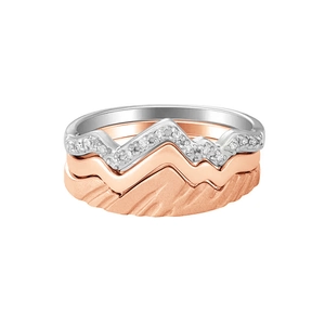 Close-up of stacked S925 silver and rose gold rings with a mountain peaks design