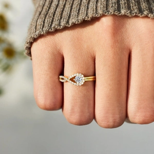 Bague infini en or élégante avec pierre centrale ronde et diamants sur le doigt d'un modèle