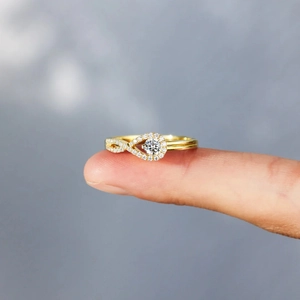 Gros plan détaillé d'une bague dorée sertie halo avec anneau infini sur le doigt