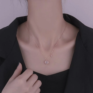 Close-up of rose gold s925 silver starburst necklace worn on neck with white gemstones