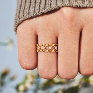 Bague en maille dorée élégante avec pierres scintillantes portée sous lumière douce