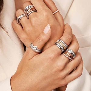 Detail of stacked S925 silver mountain rings with pavé zircon stones on a model's hand