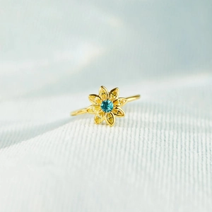 Macro shot of s925 silver sunflower ring with blue center and yellow petal gemstones