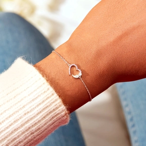 S925 sterling silver heart bracelet with pink zircons on a model wearing a white sweater