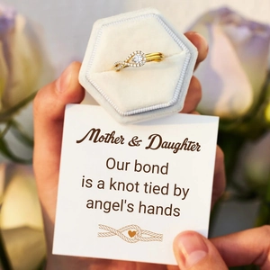 Vue rapprochée de la bague infini mère-fille dorée sertie de diamants dans son coffret