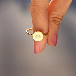 Gros plan détaillé d'une bague en argent s925 doré avec motif arc-en-ciel en émail