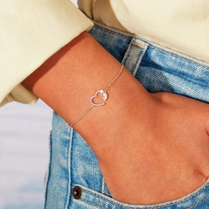 S925 sterling silver heart bracelet with pink zircon on wrist, minimalist style
