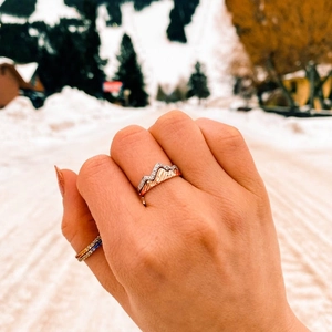 Detail of s925 silver mountain peak rings with zircons on hand with snowy background