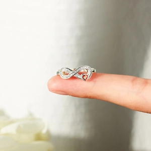 Macro shot of S925 silver infinity ring with a red heart gemstone and white zircons