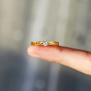 Vue détaillée d'une bague tressée en argent s925 doré avec un solitaire en zircone brillant