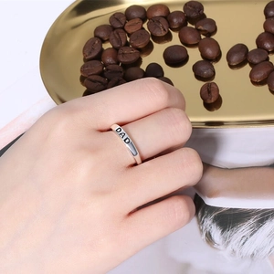 Minimalist S925 sterling silver DAD ring on hand with elegant golden tray background