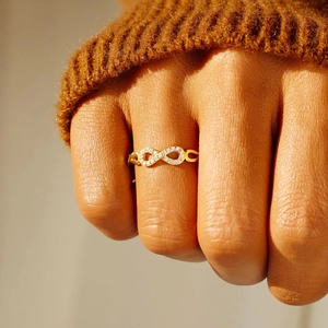 Minimalist s925 silver infinity ring in gold with pavé cubic zirconia worn on index finger